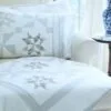 Stardust Shimmer Quilt displayed over chaise with Blue Vase