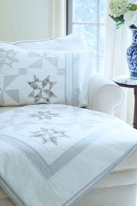 Stardust Shimmer Quilt displayed over chaise with Blue Vase