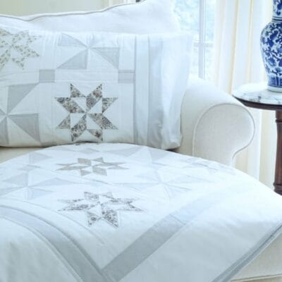 Gallery 3 Stardust Shimmer Quilt displayed over chaise with Blue Vase