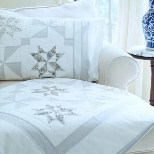 Stardust Shimmer Quilt displayed over chaise with Blue Vase